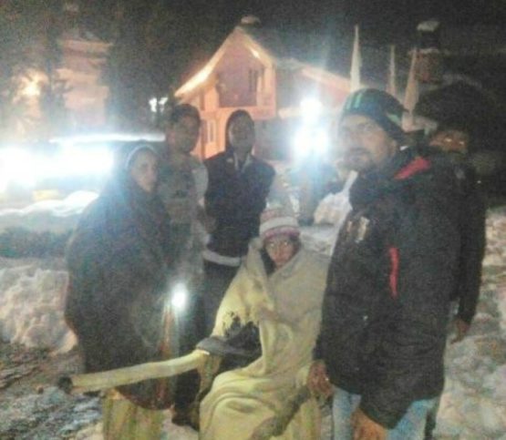 Policemen getting ready to carry Kamini to hospital in heavy snow. 
